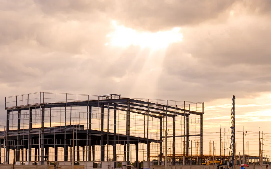 Multistorey steel building frame against an evening sky